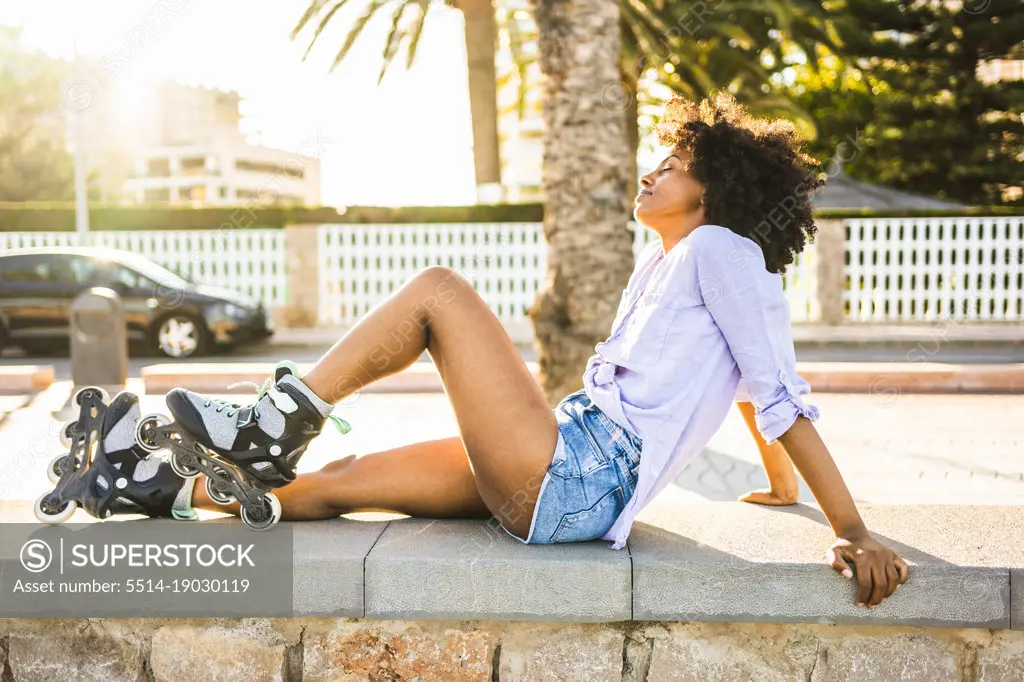 Beautiful young black woman resting relaxed with her roller skates