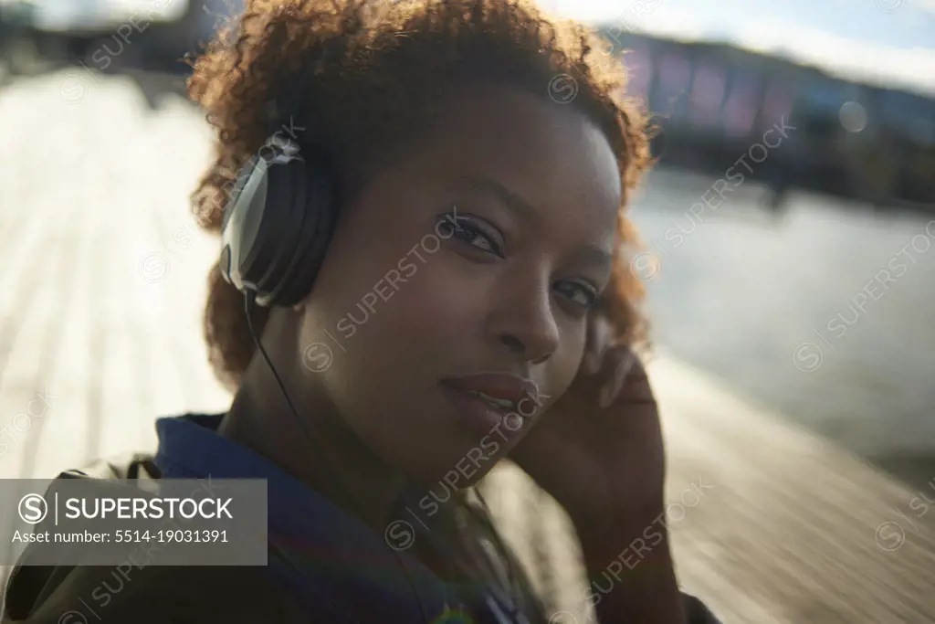 Portrait of a young black female with big afro hair wearing headphones