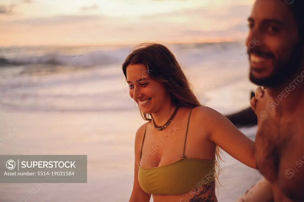 a beauty girl and her boyfriend smiling on the beach