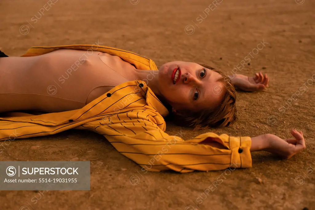 woman with orange cloth lies in desert