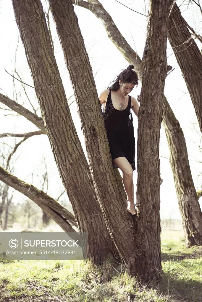 natural woman in black dress barefoot in tree and sunshine in germany