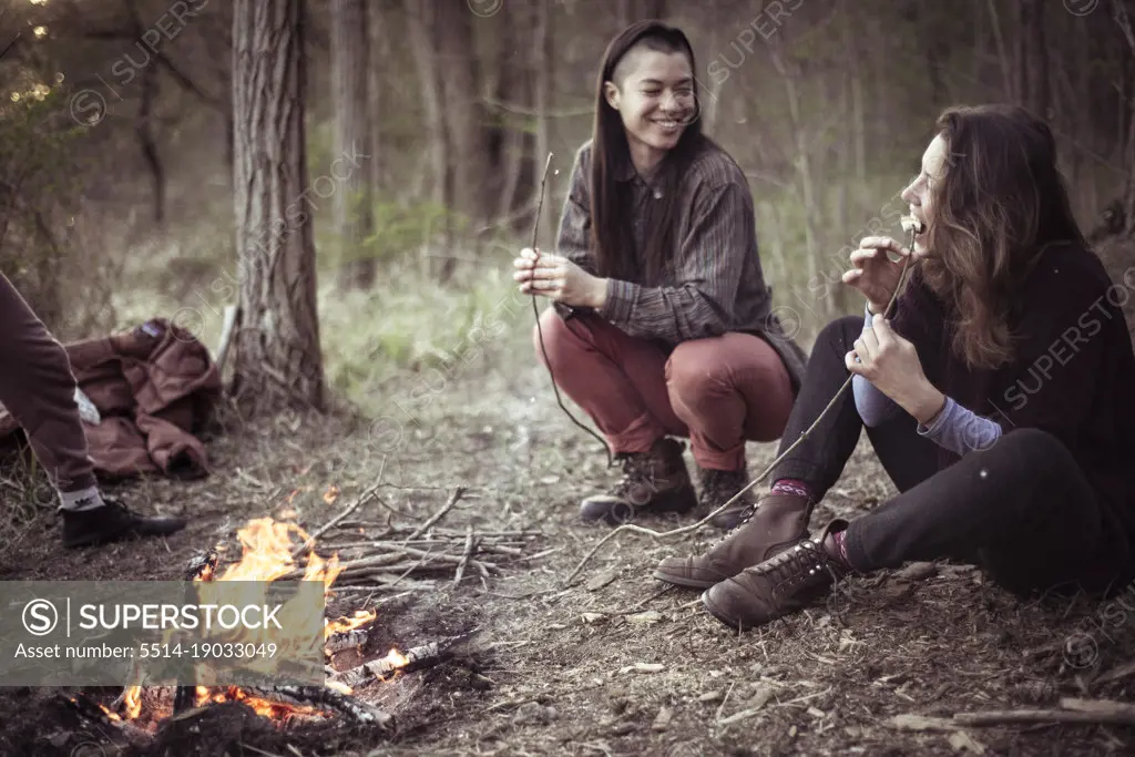 smiling androgynous women eating marshmallows