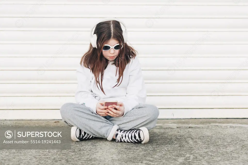 Girl sitting wearing sunglasses and listening to music