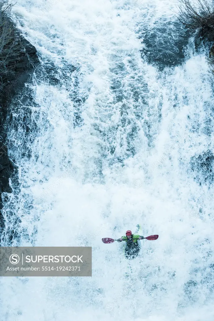 Athletic man kayaking white water