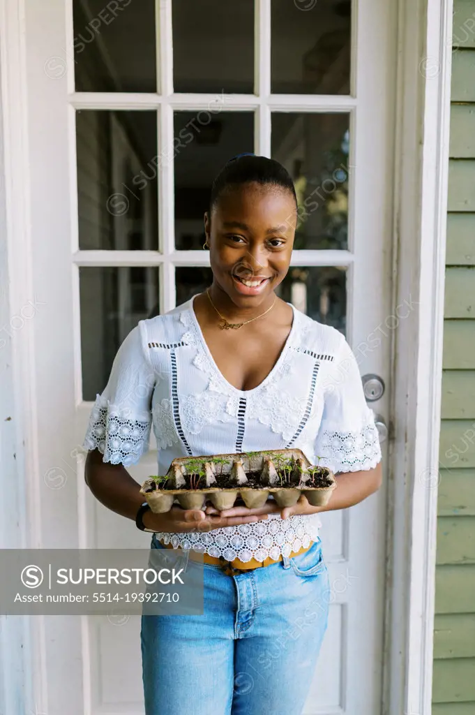 Young girl showing off her sustainable approach to growing seedlings