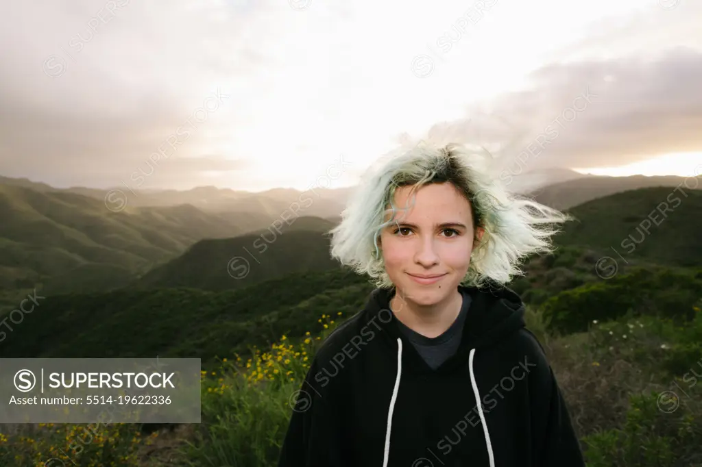Blue Haired Teen Girl On Top Of A Mountain At Sunset