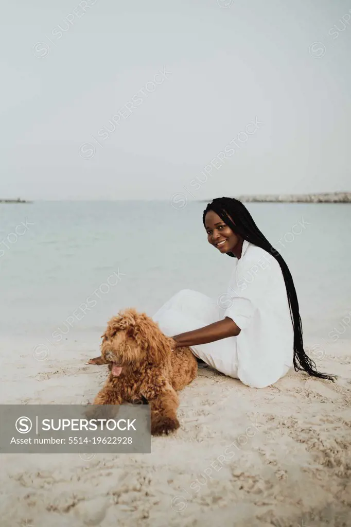 Woman playing with her dog at the beach
