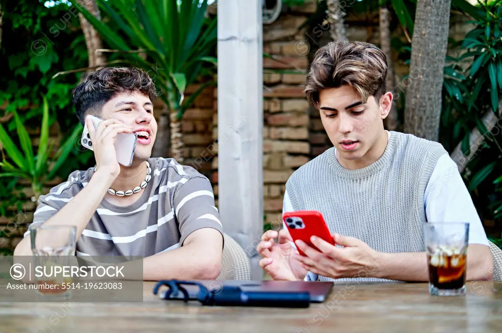 Gay Couple Outdoors Using Phone