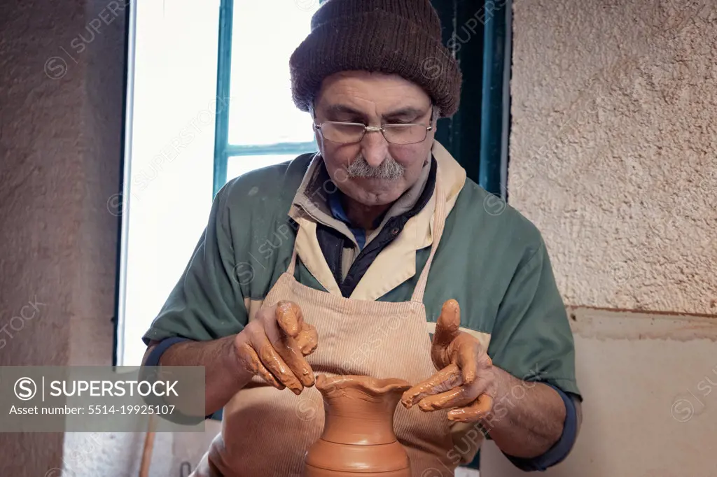 old man work the clay pottery
