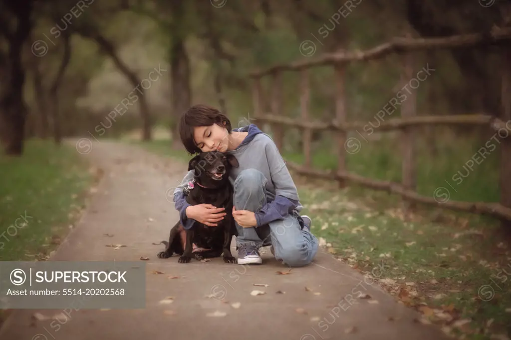 Boy Hugging Dog In Path