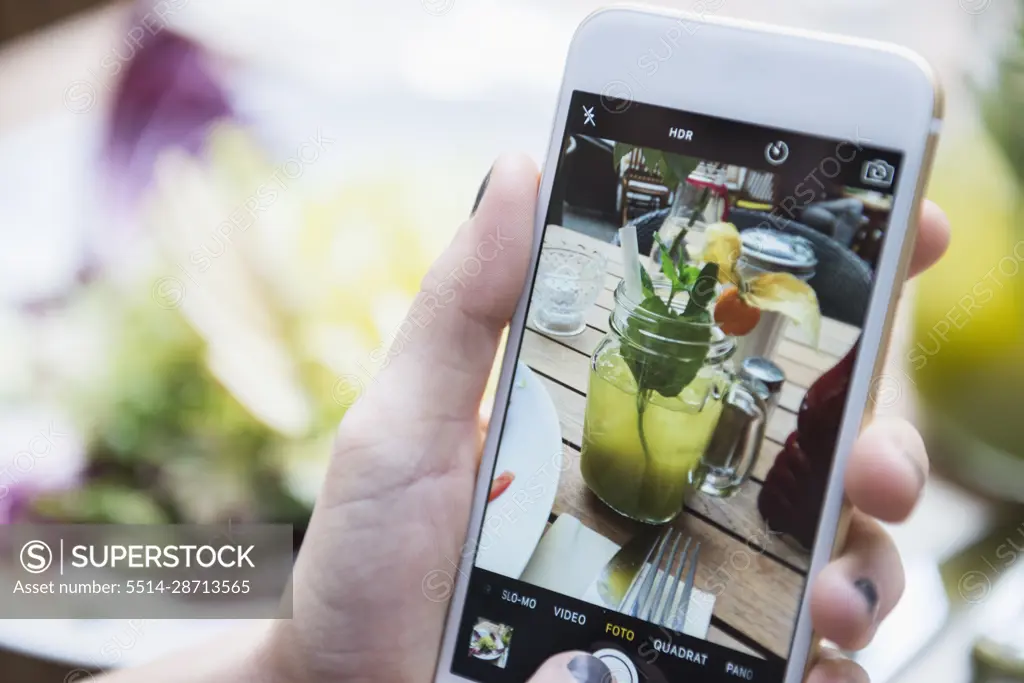 Hands of woman taking picture of mocktail