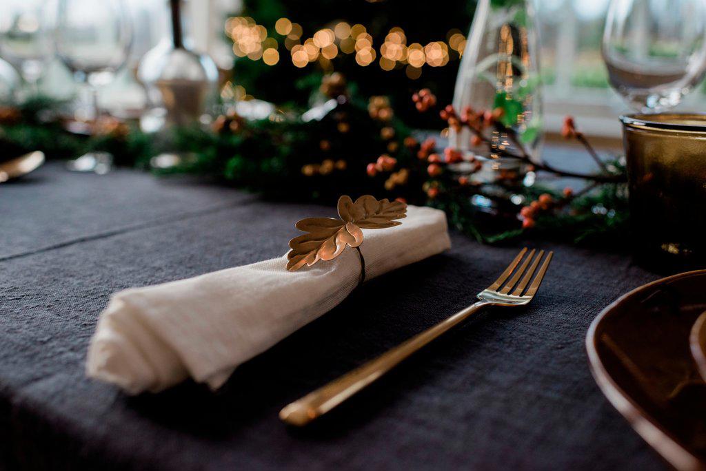 gold napkin holder on a decorated dinner table with candles