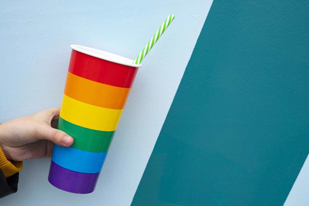 Hand picking up a rainbow pride cup