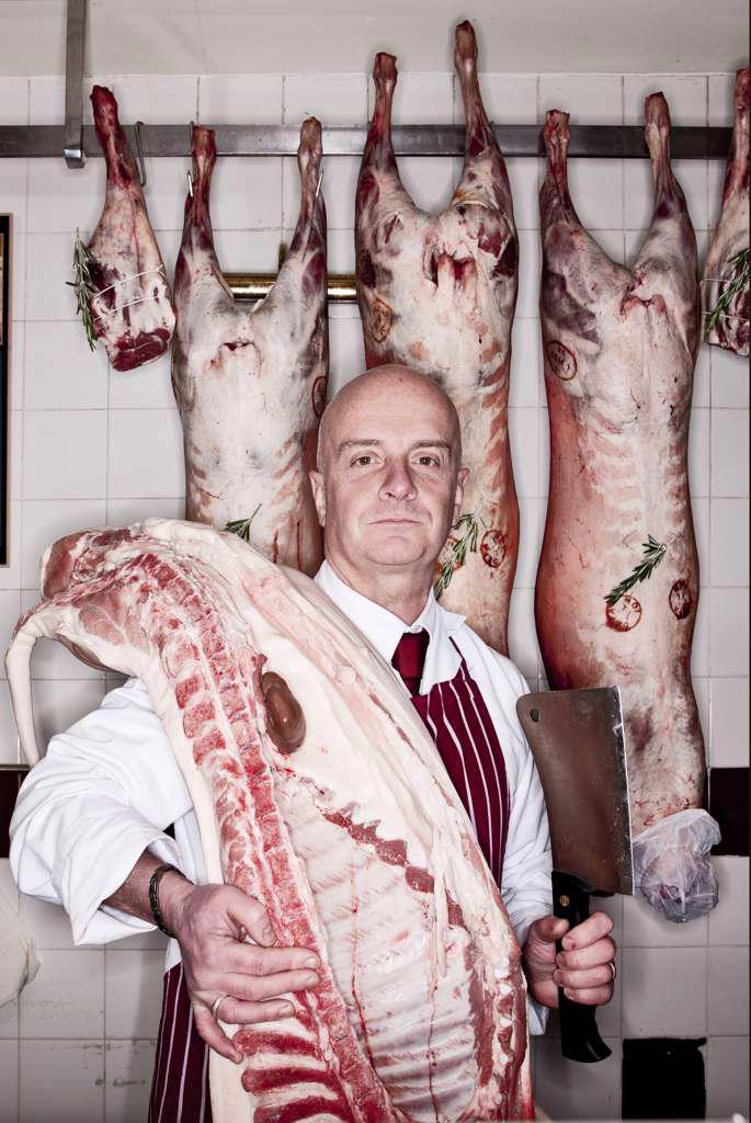 Butcher carrying pig carcass on his shoulder