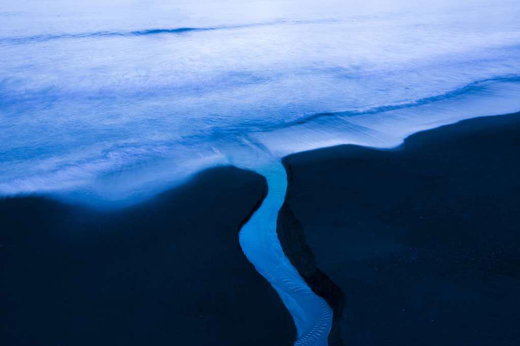 Smll Stream Returns Water to Ocean in Aerial Beach