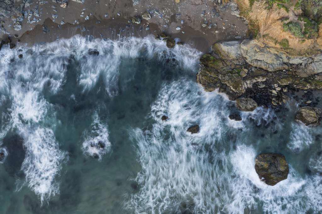 Waves Break on Rugged California Coastline Aerial