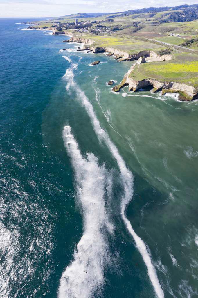 Rock formations and breaking waves in aerial over San Simeon CA