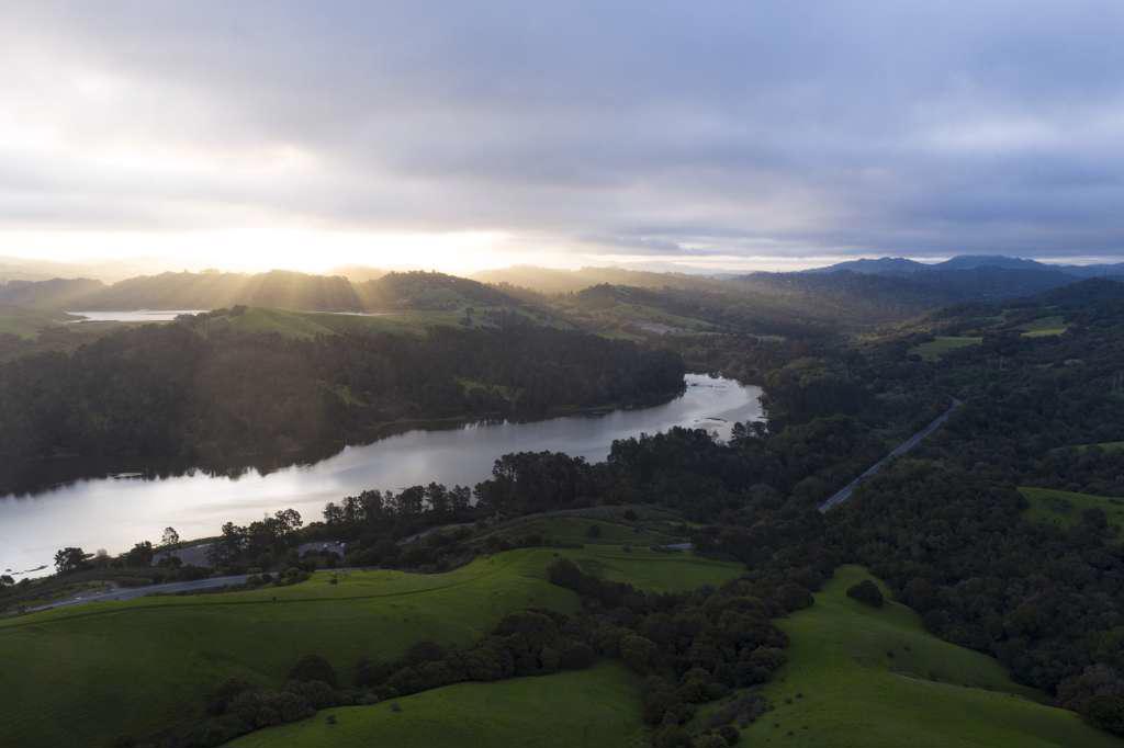 A Brilliant Sunrise Spreads Ray across Green Mountain Valley and Lake