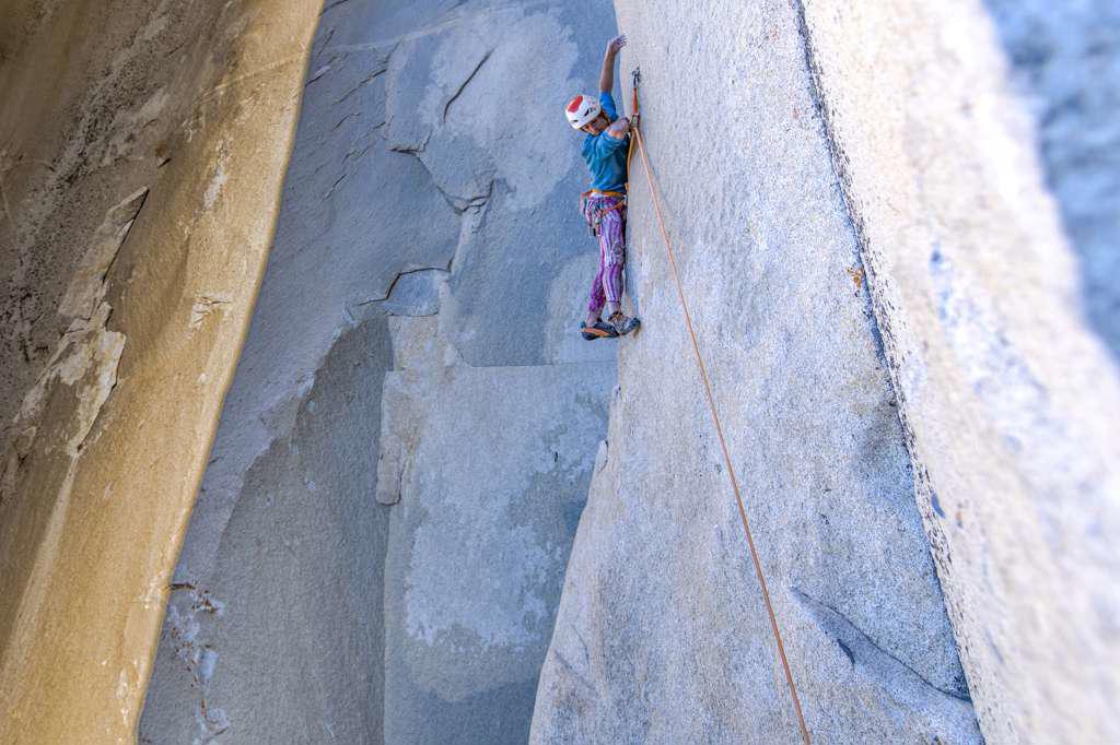Rock climber looking down while climbing on big wall in Yosemite