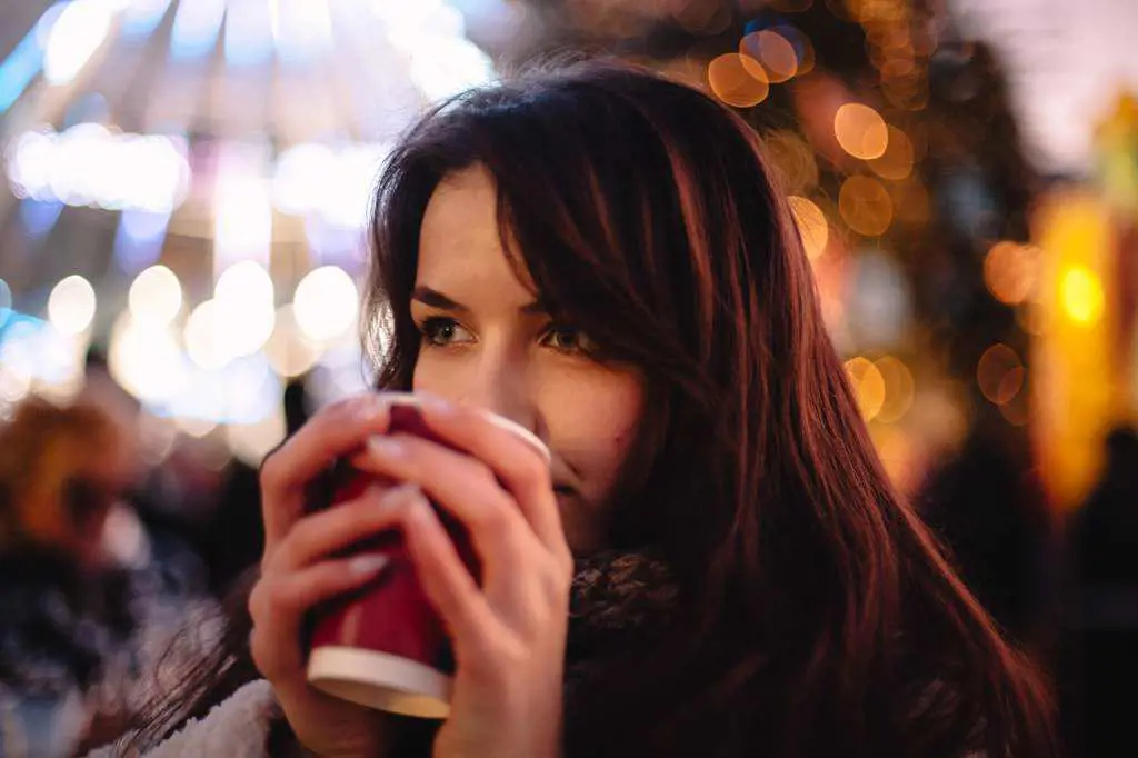 Portrait of teenage girl drinking mulled wine in Christmas market