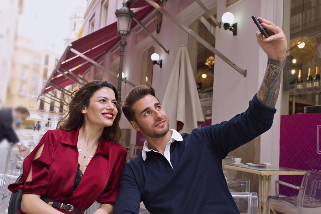 Young couple take a selfie with the mobile on the terrace of a b
