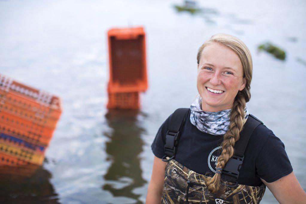 portrait of female shellfish farmer standing in water