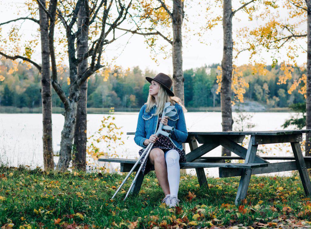 injured woman sat with her crutches enjoying the fresh air