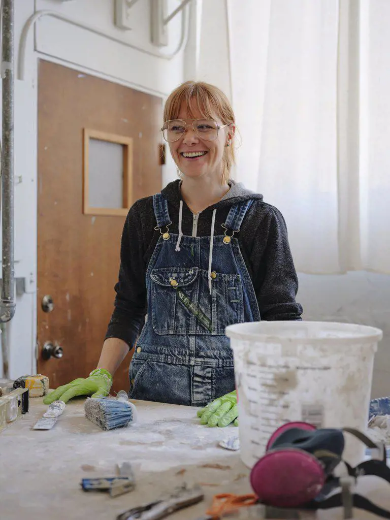 Portrait of professional female sculptor in her studio.