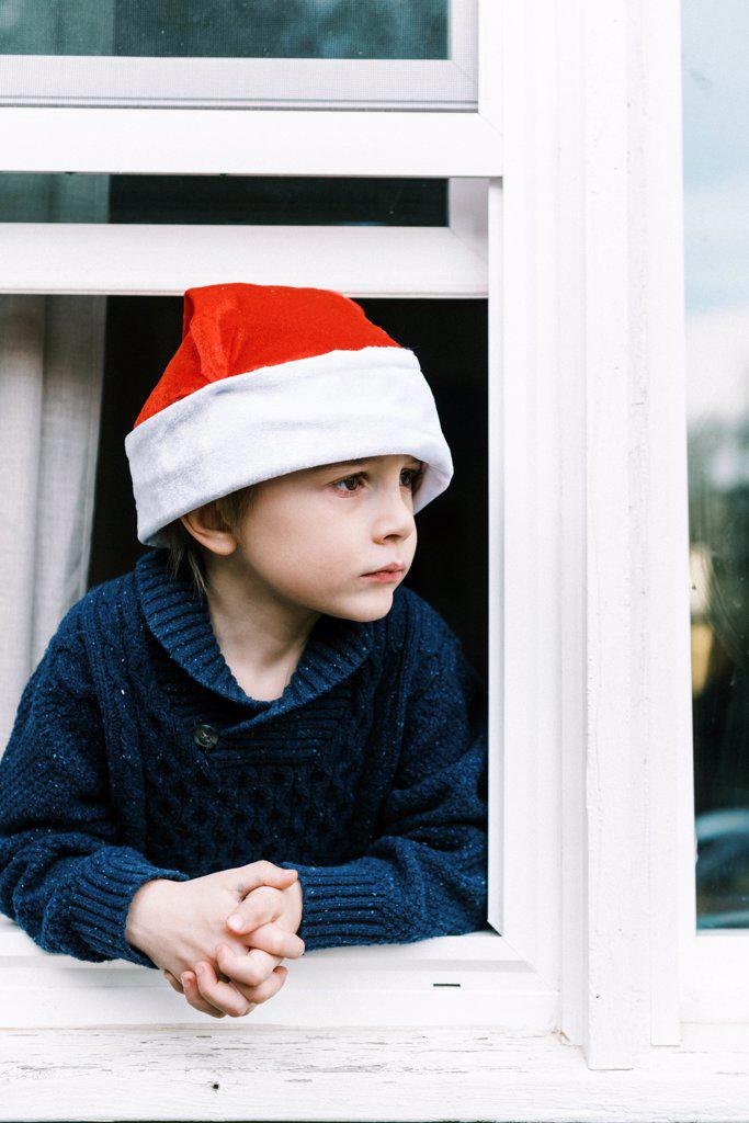 Little boy looking out window waiting for Santa clause on Christmas
