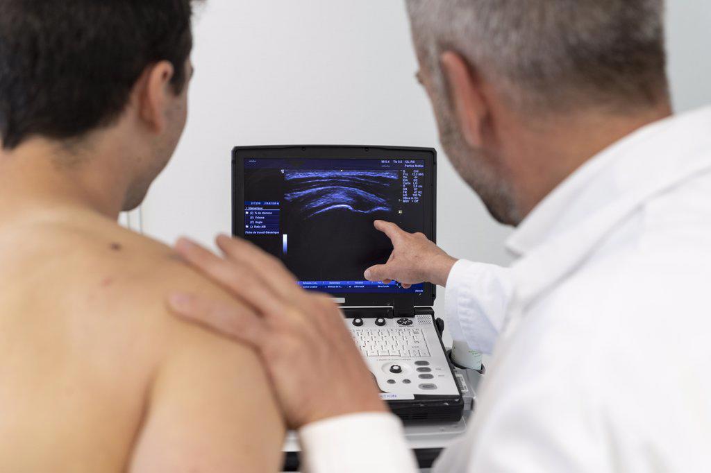 a doctor shows the results of an ultrasound to a patient