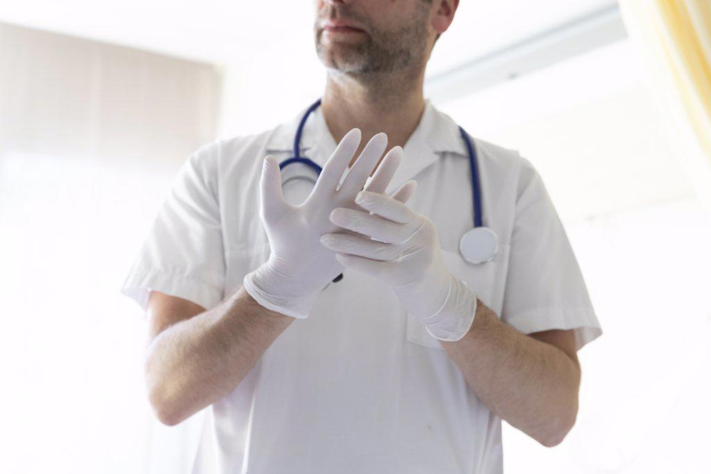 a doctor puts on gloves before an exam