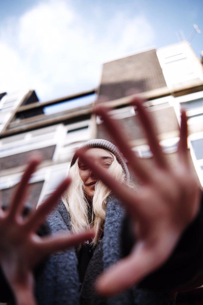 vertical shot of young female gesturing with her hands while looking at camera. low angle shot