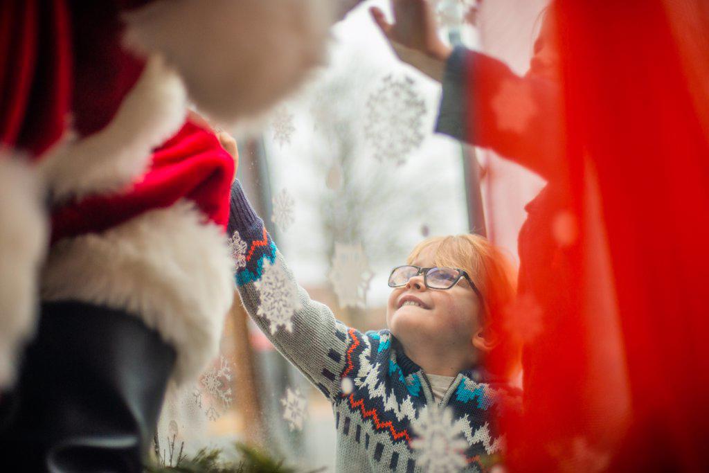 Young boy reaches up to connect to Santa during covid