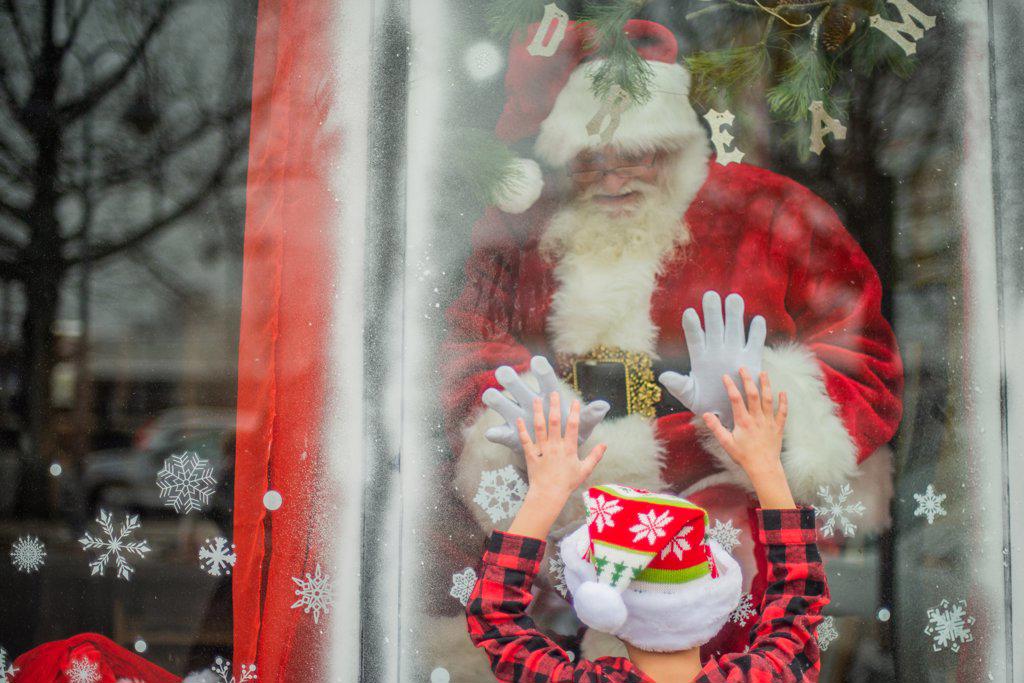 Young Boy connects with Santa in window