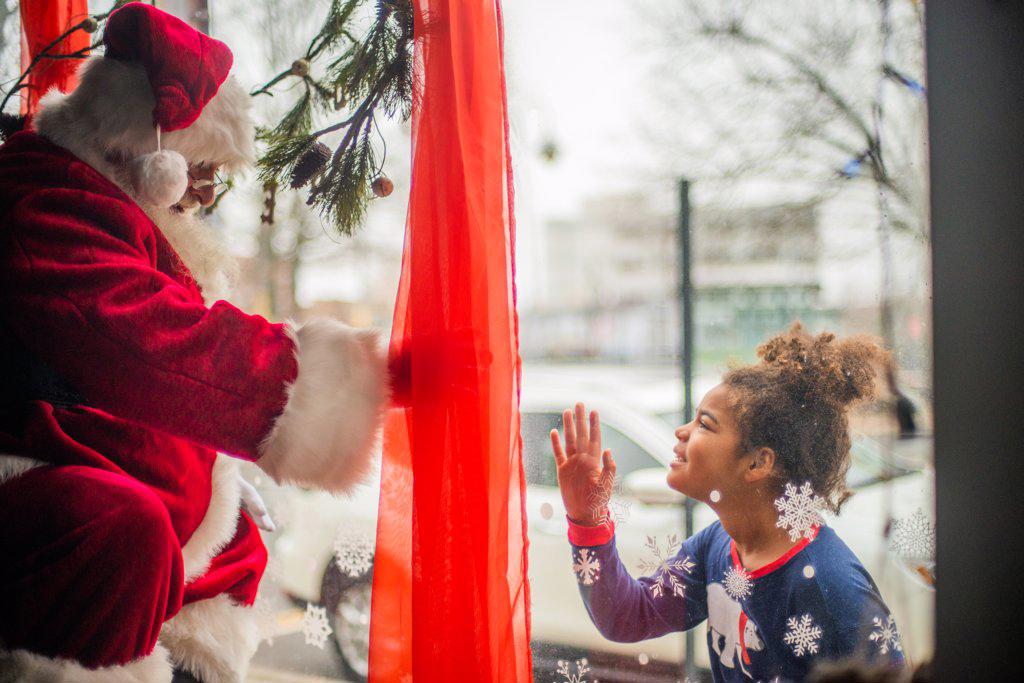 Young tween girls connects with Santa in window