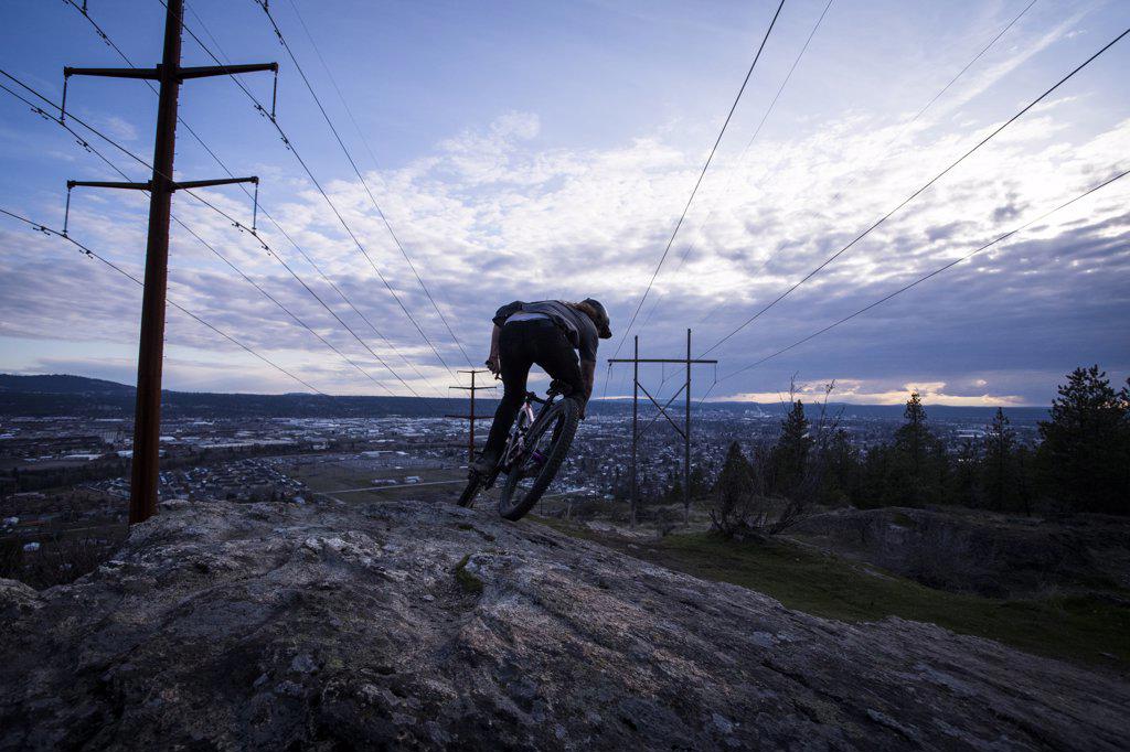 Mountain biker dropping down towards town in Spokane bike trails