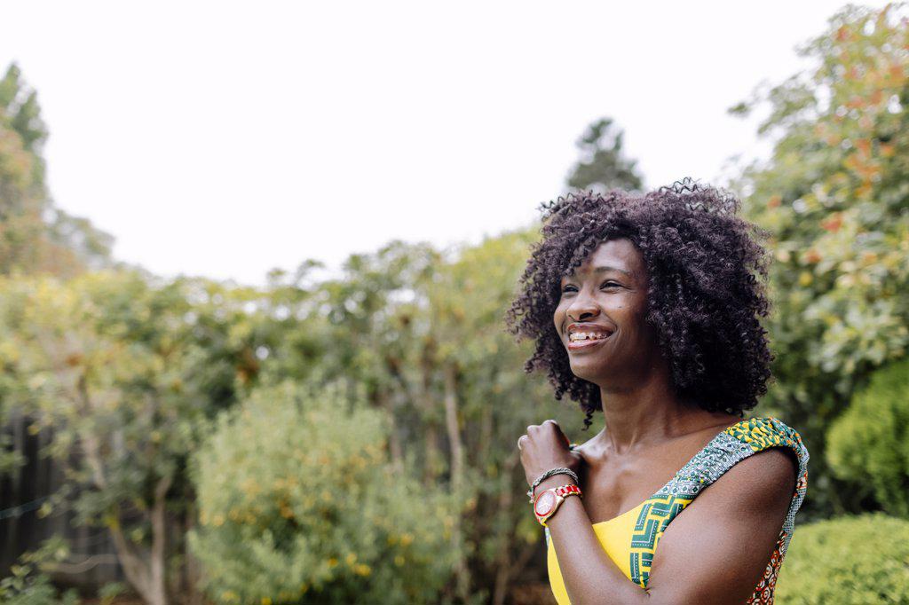Outdoor portrait profile afro hair woman with braces by garden