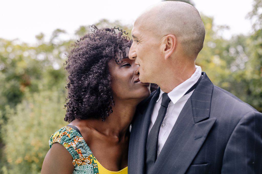Portrait happy diverse couple hugging each other by garden