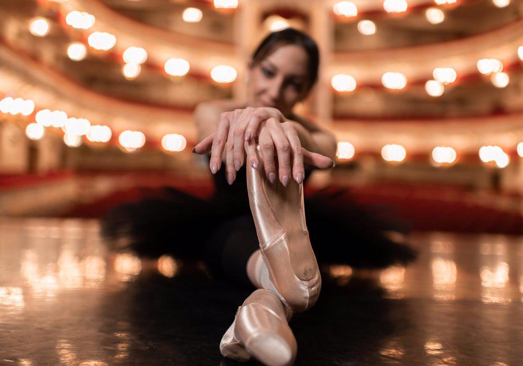 Ballerina stretching on stage before performance