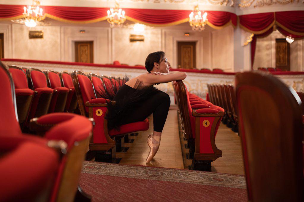 Ballerina sitting in empty auditorium