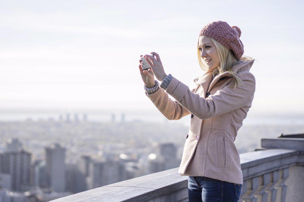 Young blonde woman using smartphone to communicate to the world