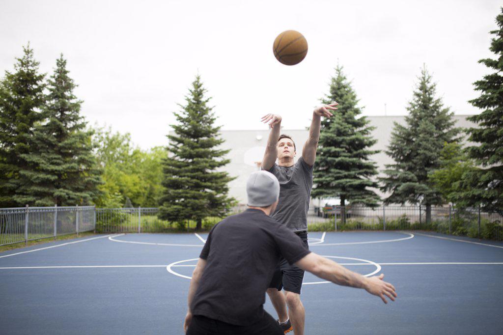 Two friends playing basketball at public courts