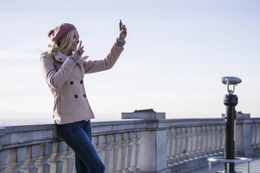 Female solo traveler using smartphone to take a selfie