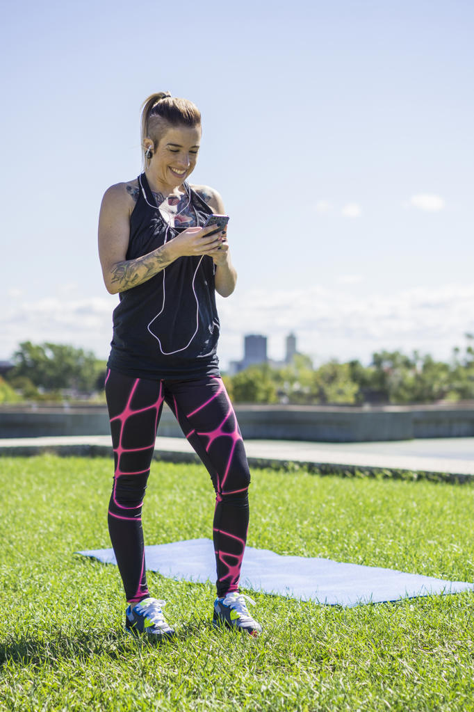 Young athletic female using smartphone while working out