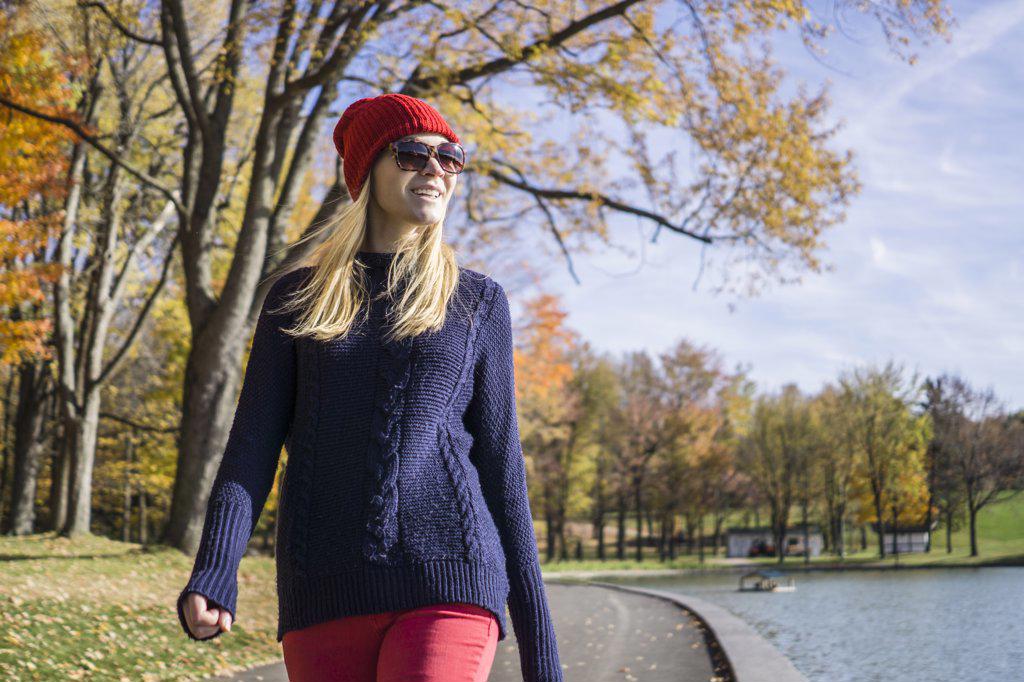 Young woman in fashionable clothing walking in park