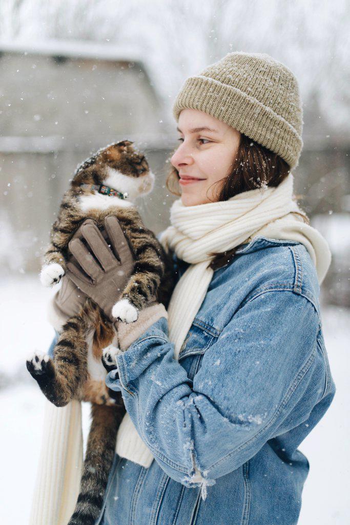 Woman holding a cat in snow