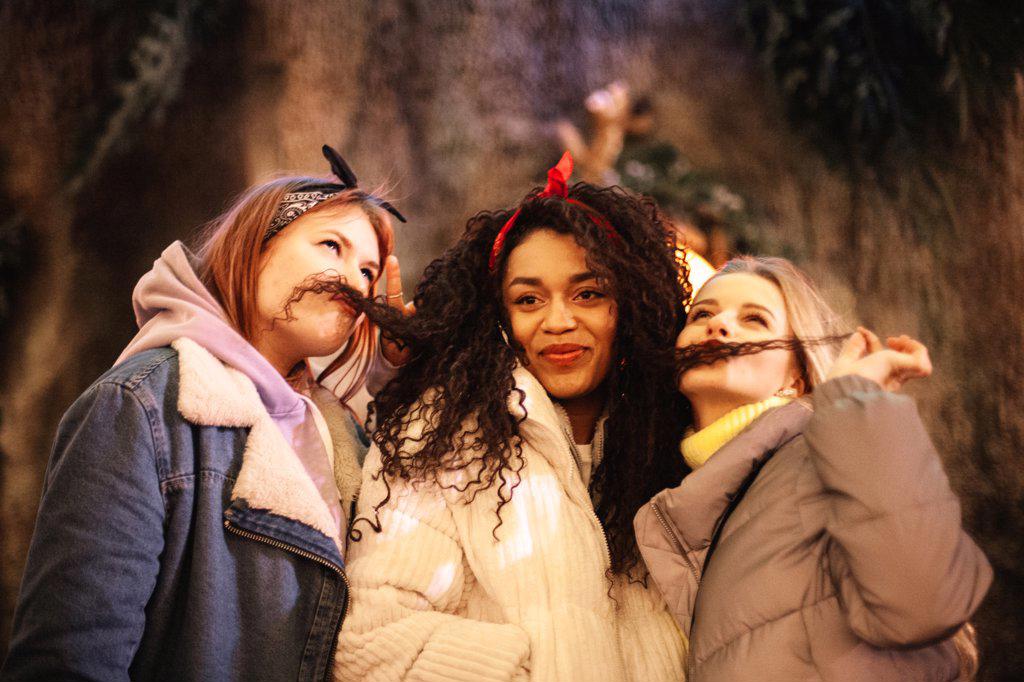 Female friends being silly making funny faces with hair mustaches