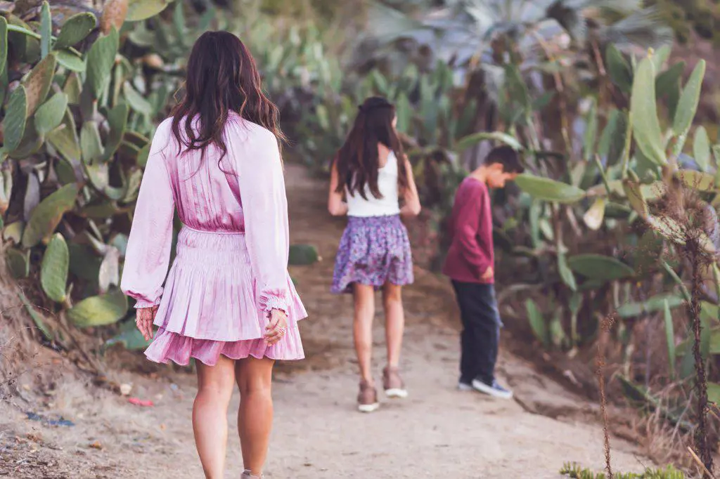 Mother walking with daughter and son on a cactus path.