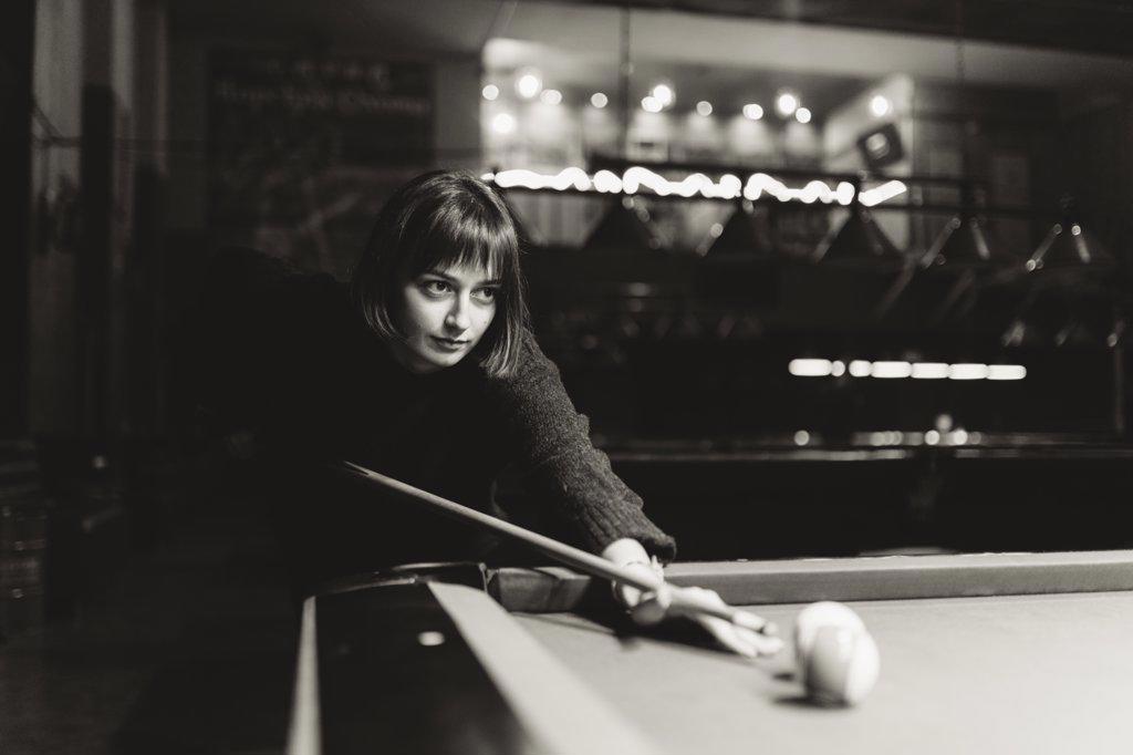 Woman with short hair playing billiards