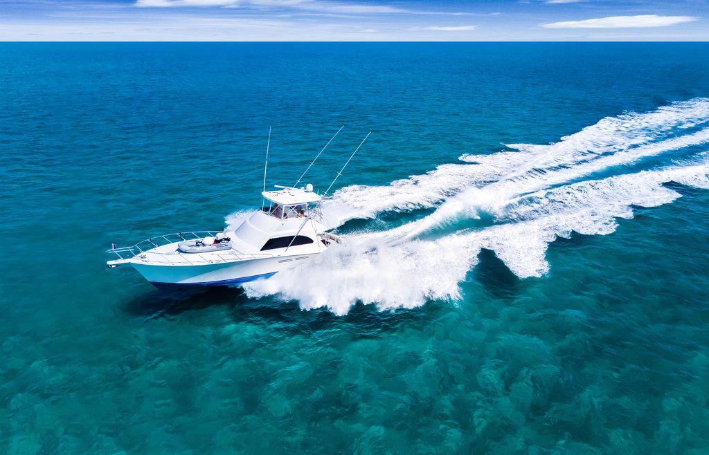 aerial view of boat driving across aqua water in the Bahamas